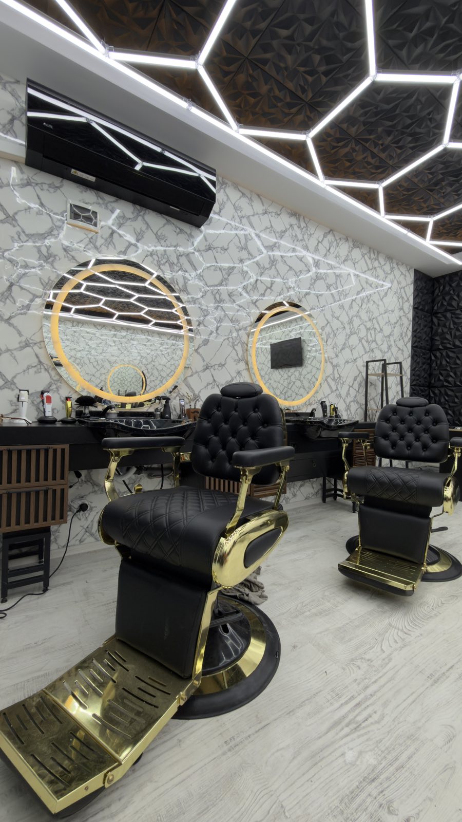 Интериор на The Barber King с черно-златни бръснарски столове